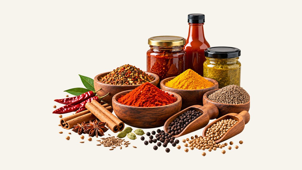 Bowls of chilli powder, turmeric and garam masala with whole spices, pastes and sauces